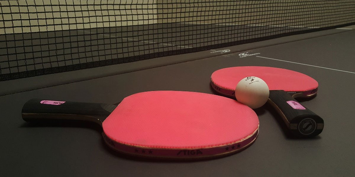 Pálky na stolní tenis na pingpongovém stole.